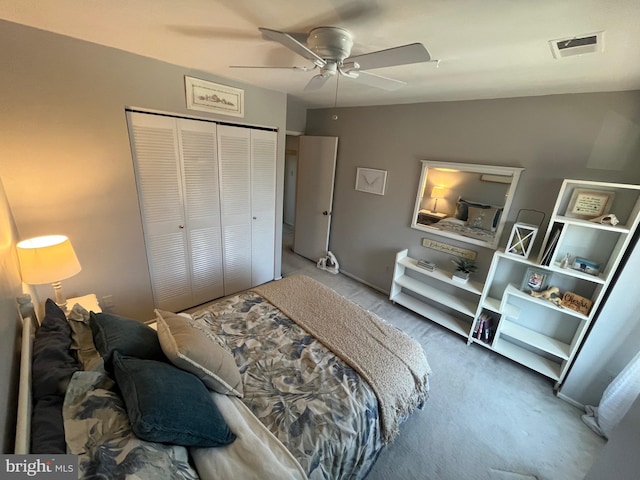 carpeted bedroom featuring a closet, visible vents, and a ceiling fan