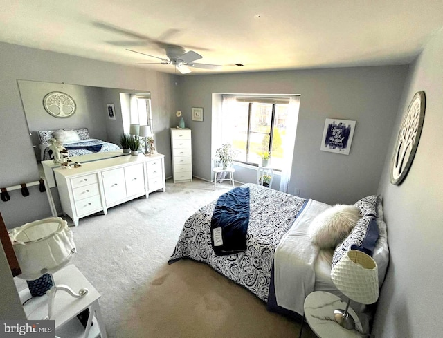 bedroom featuring light colored carpet and a ceiling fan