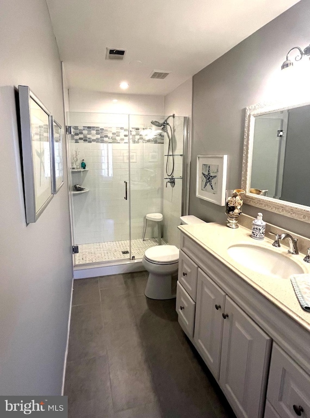 full bathroom featuring vanity, toilet, visible vents, and a stall shower