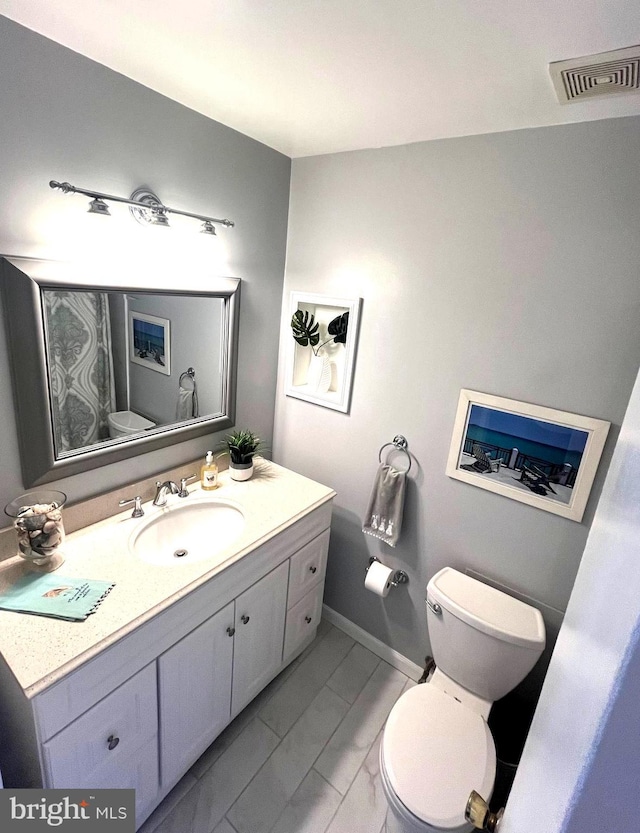 bathroom featuring visible vents, baseboards, toilet, and vanity