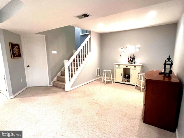 interior space featuring stairway, visible vents, and light carpet