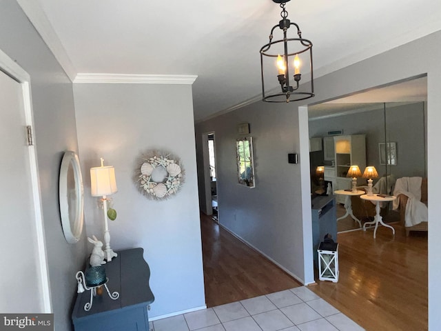 foyer featuring an inviting chandelier, crown molding, and wood finished floors