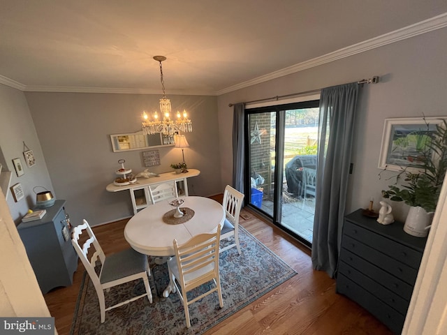 dining room featuring a chandelier, wood finished floors, and ornamental molding