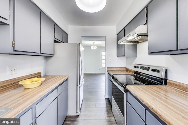 kitchen with under cabinet range hood, baseboards, dark wood-type flooring, and appliances with stainless steel finishes