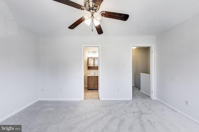 unfurnished bedroom with a ceiling fan, light colored carpet, baseboards, and connected bathroom