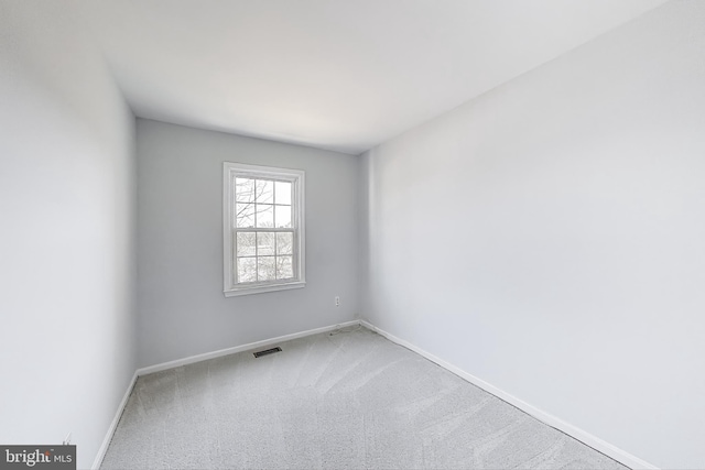 carpeted empty room with visible vents and baseboards