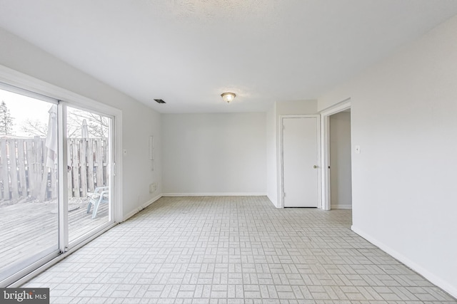 unfurnished room with visible vents and baseboards