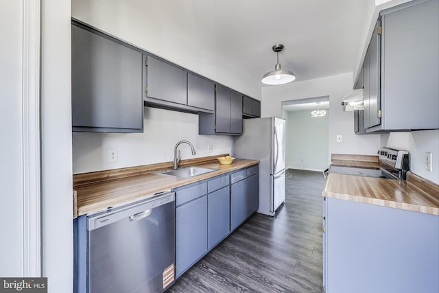 kitchen featuring ventilation hood, dark wood finished floors, a sink, stainless steel appliances, and wood counters