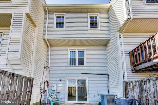 back of house with central AC unit and fence