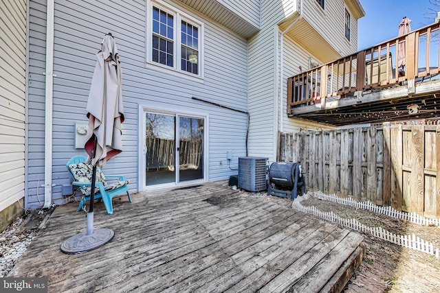 wooden deck with central AC unit and fence