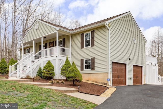 view of front facade featuring stairway, an attached garage, covered porch, and driveway