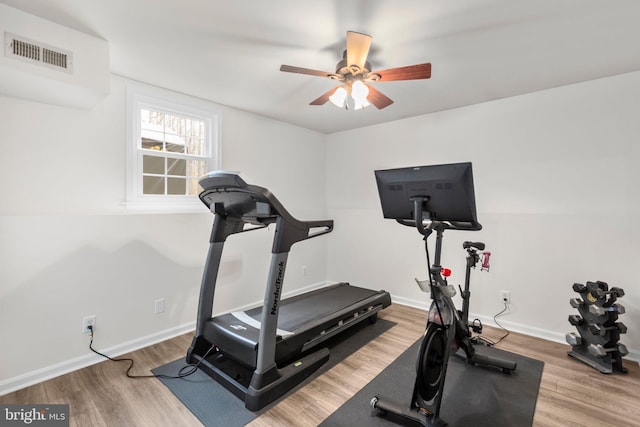 exercise area with visible vents, baseboards, a ceiling fan, and wood finished floors