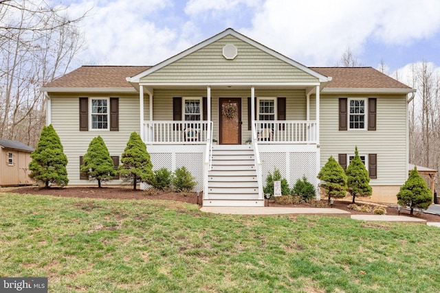 view of front of house with covered porch, a shingled roof, stairs, and a front yard