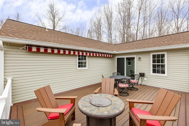 wooden terrace with outdoor dining space and an outdoor fire pit