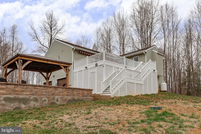 view of property exterior featuring a deck, a gazebo, stairway, and a garage