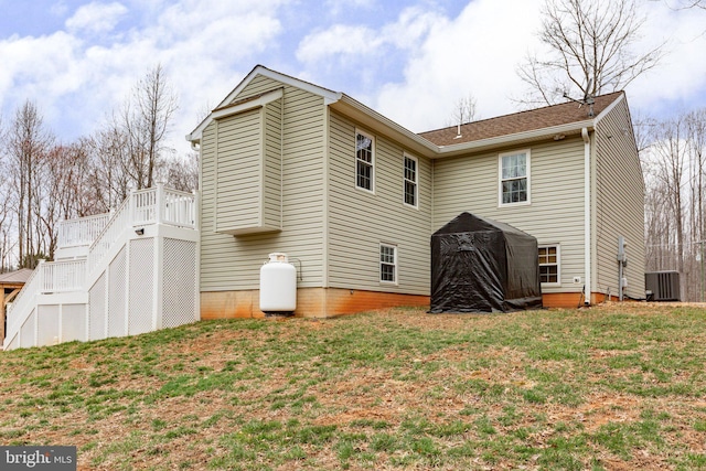 back of house with a lawn and central AC