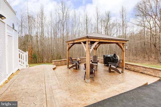 view of patio featuring a gazebo, grilling area, and a forest view