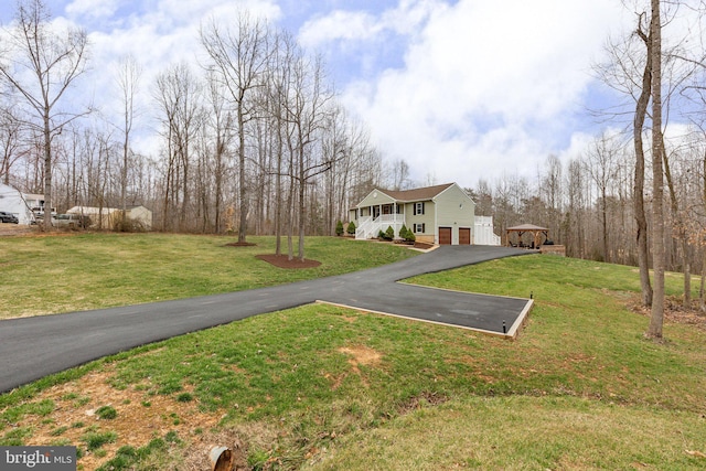 view of yard featuring aphalt driveway and an attached garage