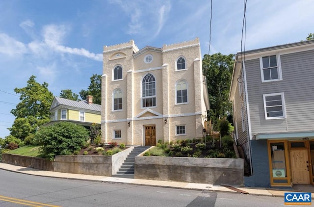 view of front of house with stucco siding and stairs