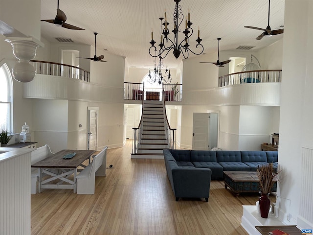 living area featuring a high ceiling, wood finished floors, and visible vents