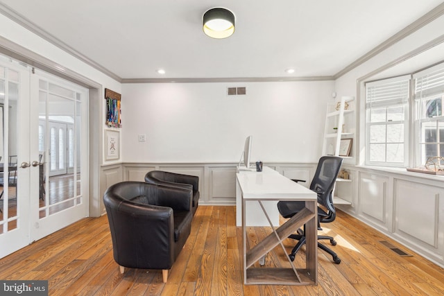 office area with crown molding, visible vents, and light wood-type flooring