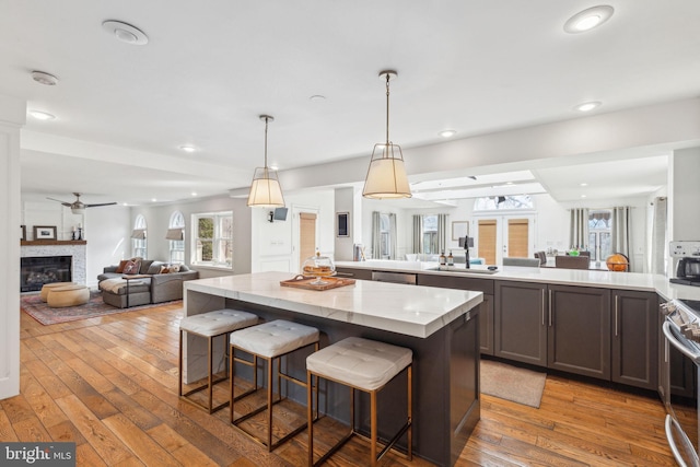 kitchen with a glass covered fireplace, hardwood / wood-style flooring, open floor plan, and a sink