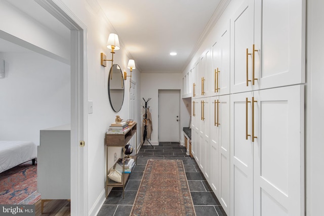 hallway featuring stone finish flooring, baseboards, and crown molding