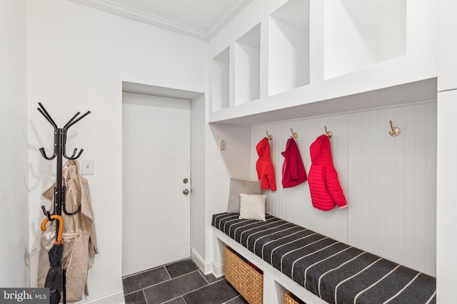 mudroom with dark tile patterned flooring and crown molding