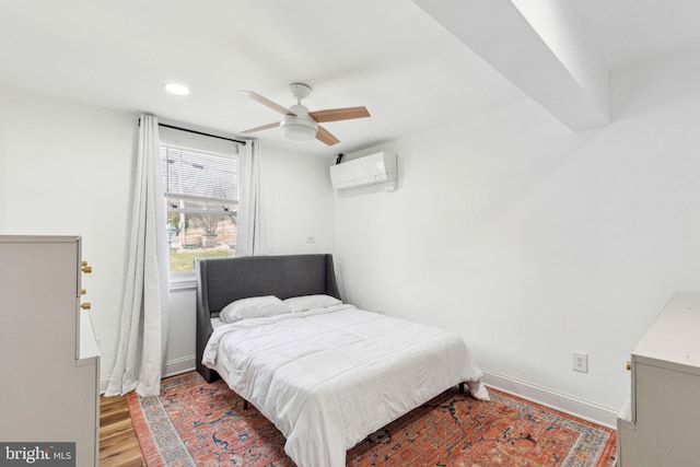 bedroom featuring a ceiling fan, wood finished floors, baseboards, recessed lighting, and an AC wall unit