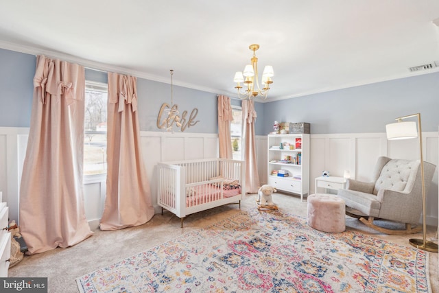 bedroom with visible vents, ornamental molding, wainscoting, carpet flooring, and a chandelier