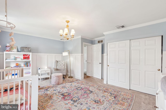 bedroom with a wainscoted wall, a notable chandelier, visible vents, and carpet floors