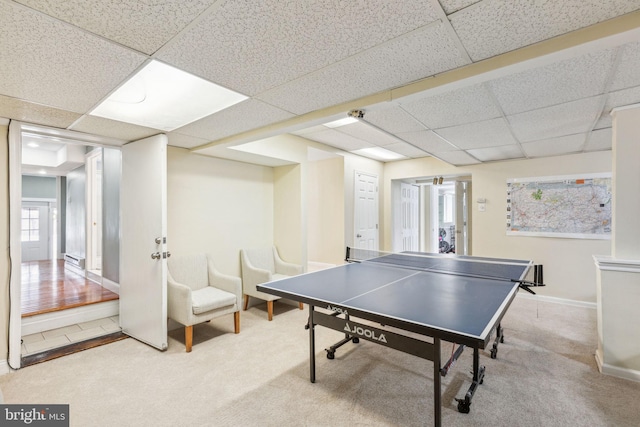 recreation room featuring baseboards, a paneled ceiling, and carpet