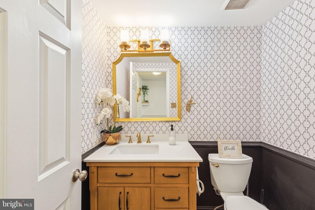 half bathroom featuring wallpapered walls, toilet, and visible vents