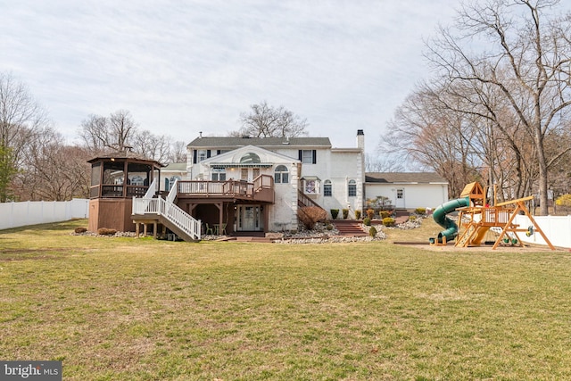 back of house with a gazebo, a lawn, a playground, and fence