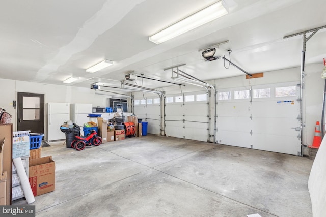 garage with a garage door opener and freestanding refrigerator