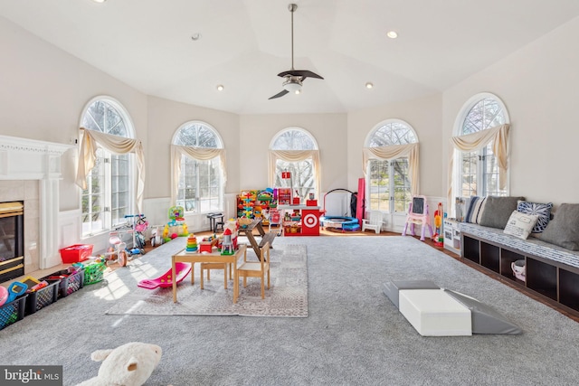 recreation room featuring plenty of natural light, a fireplace, and vaulted ceiling