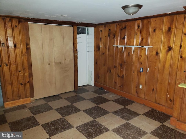 foyer entrance featuring wooden walls and dark floors