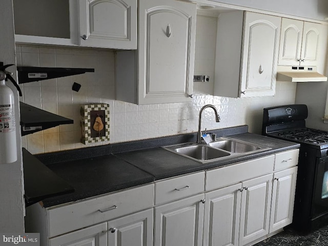 kitchen featuring a sink, black gas range, under cabinet range hood, white cabinetry, and dark countertops