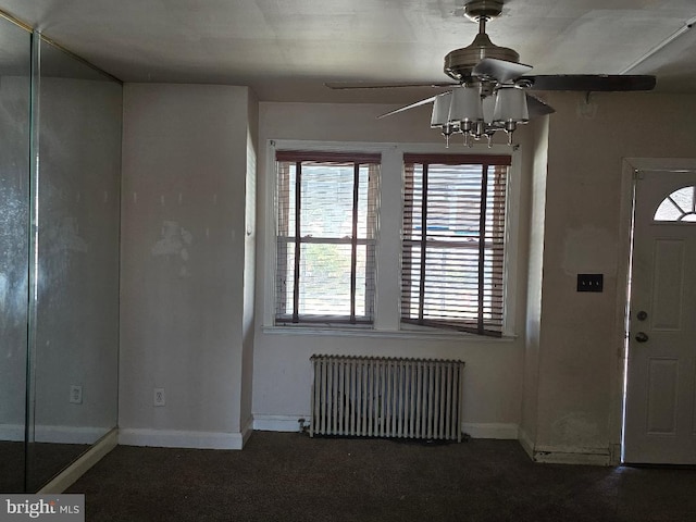 foyer with baseboards, radiator, and a ceiling fan