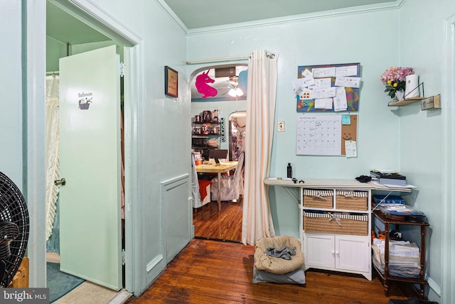 hallway featuring wood finished floors and ornamental molding