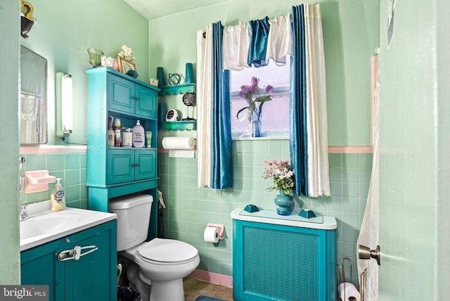 bathroom featuring toilet, tile walls, vanity, and tile patterned flooring