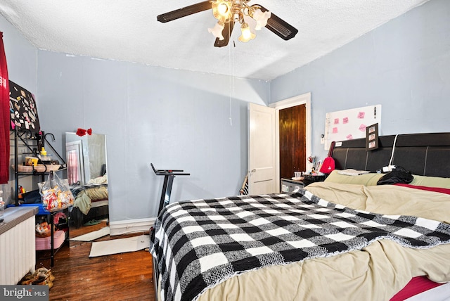 bedroom with a textured ceiling, a ceiling fan, and wood finished floors