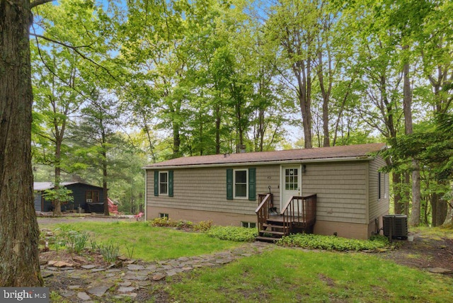 back of house featuring cooling unit and a yard