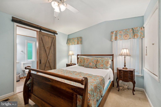 bedroom with lofted ceiling, a barn door, light colored carpet, and baseboards