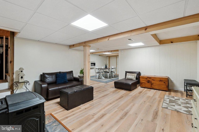 living area featuring a drop ceiling, visible vents, and wood finished floors