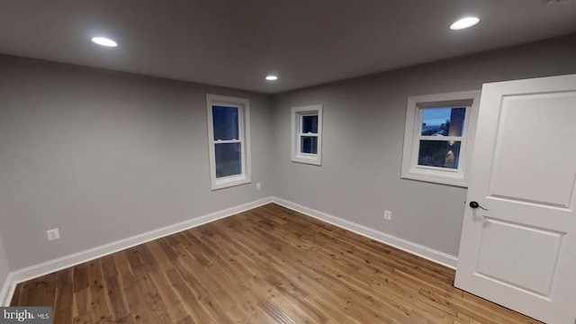 unfurnished room with recessed lighting, wood finished floors, and baseboards