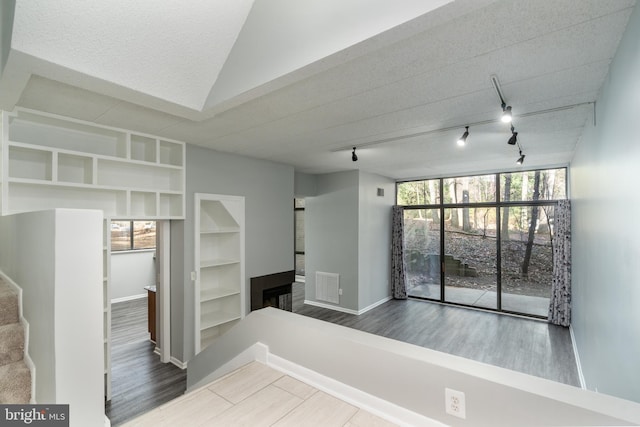 interior space with stairway, a healthy amount of sunlight, baseboards, and visible vents