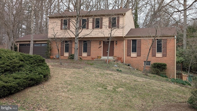 colonial inspired home with a front lawn, a garage, brick siding, and a chimney