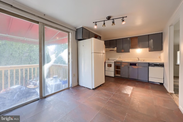 kitchen with baseboards, under cabinet range hood, light countertops, white appliances, and a sink