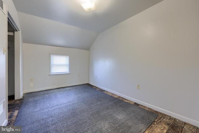 unfurnished bedroom with baseboards and lofted ceiling